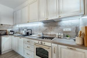 a kitchen with white cabinets and a stove top oven at Villa Goranovic in Herceg-Novi