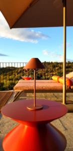 a red table with an umbrella on a balcony at Casa Dr Ramiro Salgado - Douro Superior, Torre de Moncorvo in Torre de Moncorvo