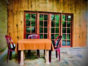 a dining room table with two chairs and a window at wilpattu lake nest in Horuwila