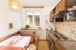 Una pequeña cocina con una mesa y una ventana. en Ferienappartements Brandner, en Bad Hofgastein