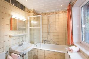 Un baño con lavabo y bañera y un lavabo. en Ferienappartements Brandner, en Bad Hofgastein 20 fotos más
