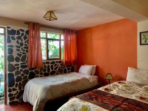 una camera da letto con due letti e una finestra di Kiswar Lodg a Ollantaytambo