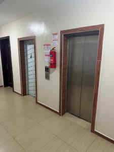 ein Flur mit zwei Aufzügen und einem Feuerlöscher in der Unterkunft studio Bi in Grand Médina