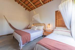 een slaapkamer met 2 bedden en een hangmat bij Casa Teçá in Guriú +48 foto's
