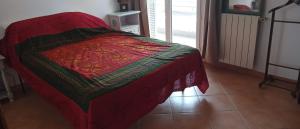 a bed with a red blanket on top of it at appartement T2 tout confort in Bastia