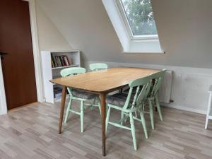 a wooden table and chairs in a room with a window at Farmen - beautiful view among animals in Ornebjerg