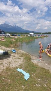 a young child playing in the water at a lake at Chata pod zubačkou in Tatranska Strba