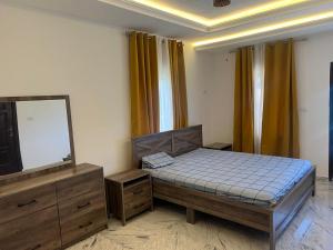 ein Schlafzimmer mit einem Bett, einem Spiegel und einem Fernseher in der Unterkunft Nana's Duplex Apartment in Marshall