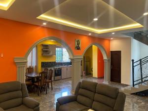 ein Wohnzimmer mit orangefarbenen Wänden sowie einem Tisch und Stühlen in der Unterkunft Nana's Duplex Apartment in Marshall