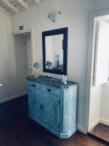 a blue cabinet in a room with a mirror at Casa da Cisterna in São João