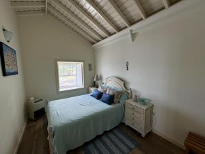 a bedroom with a bed with blue pillows and a window at Casa da Cisterna in São João