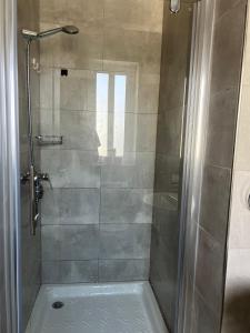 ein Badezimmer mit Dusche mit Glastür in der Unterkunft Faxxina in Is-Swieqi