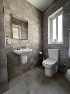 ein Badezimmer mit Toilette und Waschbecken in der Unterkunft Faxxina in Is-Swieqi + 1 Foto