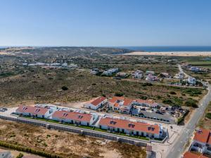 an aerial view of a town with houses and the ocean at Casa Bordeira in Bordeira