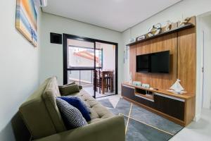 a living room with a couch and a flat screen tv at Apartamento super completo a 250mts do mar in Governador Celso Ramos