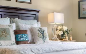 a bedroom with a bed with a lamp and flowers at Another Day on 30A by Oversee 30A in Santa Rosa Beach