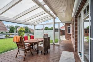 a patio with a wooden table and chairs at Traumhaus mit Garten in Reppenstedt