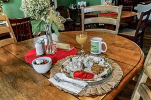 un tavolo con un piatto di cibo e un bicchiere di vino di Rustic Attic Room at Main Street Bed & Breakfast a Glasgow