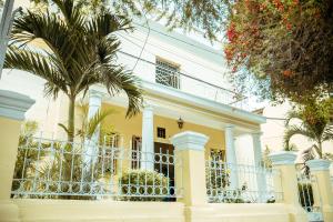 una casa gialla con una palma di fronte di Hotel Las Palmeras a Piura