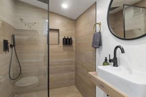 une salle de bains avec douche, lavabo et miroir dans l'établissement 5BD Home with outdoor space in Little Italy, à San Diego