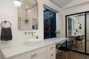 une salle de bain blanche avec un lavabo et un miroir dans l'établissement Quaint Studio for 2 in the Heart of Little Italy, à San Diego 18 autres photos