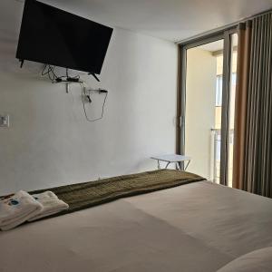 a bedroom with a bed with a flat screen tv on the wall at HOTEL LA VIEJA SARA RIOHACHA in Ríohacha