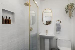 une salle de bain avec un lavabo, des toilettes et un miroir dans l'établissement Cozy 1 BR Casita Overflowing with Natural Light, à San Diego