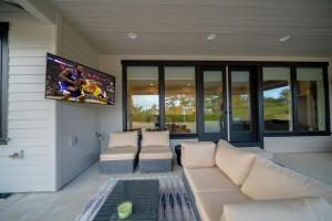 a living room with a couch and a flat screen tv at Gearhart Getaway - Gated Community Home w/ Hot Tub, Walk to Beach in Warrenton