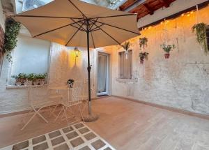 a large umbrella in a room with a table and chairs at Airoldi Palace Apartment in Chioggia