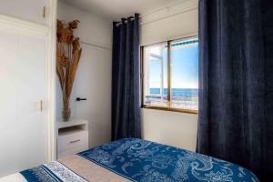 a bedroom with a window with a view of the ocean at Sea View La Mata Apartment in La Mata
