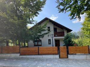 a house with a wooden fence in front of it at Casa de vacanta Mogosa in Baia-Sprie