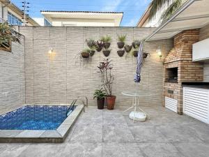 a swimming pool with a table and an umbrella at Piscina Privativa - Condominio - Churrasqueira - Espaçosa in Guarujá