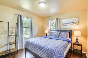 une chambre avec un lit bleu et deux fenêtres dans l'établissement about 1 Mi to University of Oklahoma Norman Cottage, à Norman