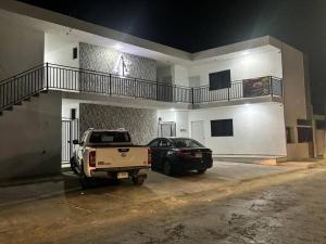 a truck and a car parked in front of a building at DePARTAMENTO AF16 in Tizimín