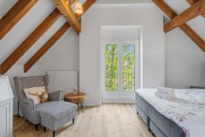 a bedroom with a bed and a chair and a window at House of Harmony in Stäfa +51 photos