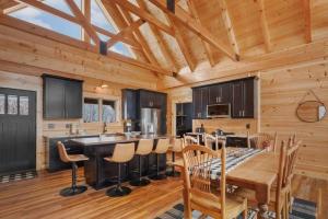 una cucina con soffitto in legno, tavolo e sedie di Big Sky Cabin at Monteagle a Banner Elk