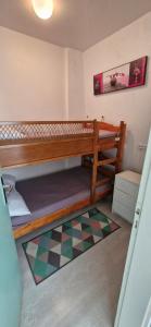 a room with two bunk beds and a checkered floor at Studio 30m plage - Marina 5 - 31 allée des pinons - 1-1 in Saint-Jean-de-Monts +2 photos