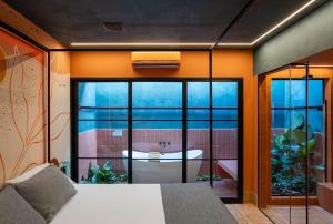 a bedroom with a view of a bathroom with a tub at Liv Motel e Hotel in Guararapes