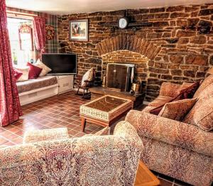 a living room with a couch and a brick wall at Butterfly Lodge quirky rural home stunning views in Bishop Auckland