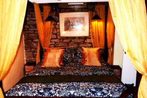 a bedroom with a bed with a stone wall at Butterfly Lodge quirky rural home stunning views in Bishop Auckland