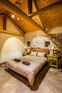 a bedroom with a large bed in a room with wooden ceilings at Guest House Podkovite in Karlovo