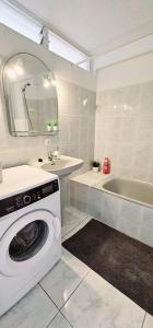 a white bathroom with a washing machine and a sink at Beach House Apartment in Adeje