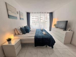 a bedroom with a large bed with a television at Beach House Apartment in Adeje