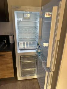 an empty refrigerator with its door open in a kitchen at 50 nuances de rouge in Guebwiller +13 photos