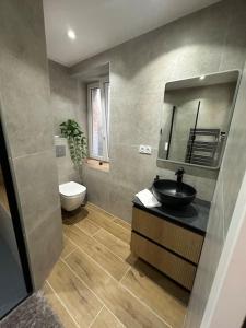 a bathroom with a sink and a toilet and a mirror at 50 nuances de rouge in Guebwiller