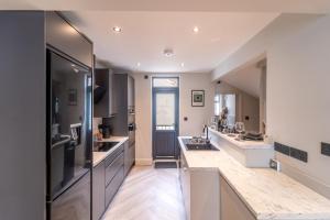 a large kitchen with stainless steel appliances and counters at Albert House - 3 Beds, Central & Racecourse! in Gloucestershire