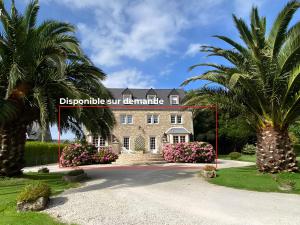 a house with two palm trees in front of it at Duplex Bellevue, vue mer, à 50m de la plage! in Réville