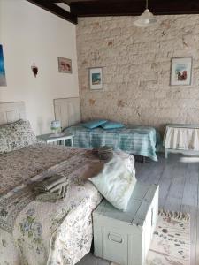 une chambre avec deux lits et un mur de briques dans l'établissement Villa Giulia B&B, à Castellana Grotte 54 autres photos