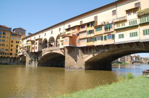 un puente sobre un río con edificios en él en Montebello New Apartment, en Florencia