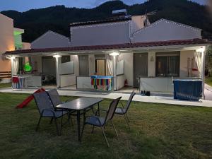 a table and chairs in front of a house at Harmony Studios & Apartments in Skala Potamias